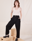 Hana is 5'3" and wearing XXS Petite Organic Trousers in Basic Black paired with Tank Top in vintage tee off-white