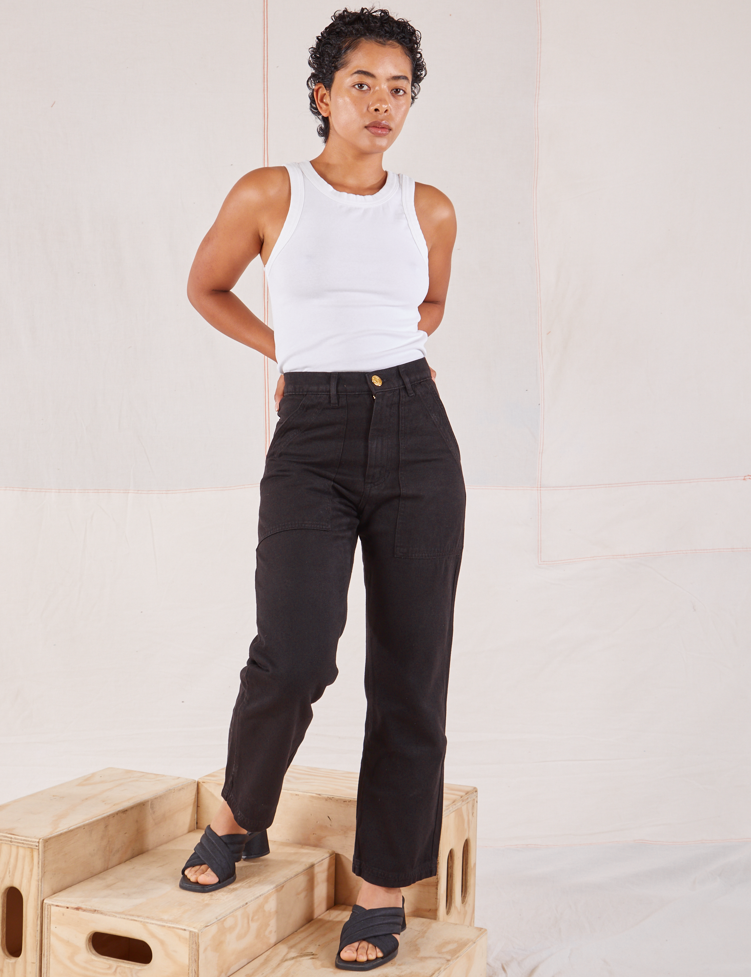 Mika is 5'1" and wearing Petite XXS Organic Work Pants in Basic Black paired with Racerback Tank in vintage tee off-white