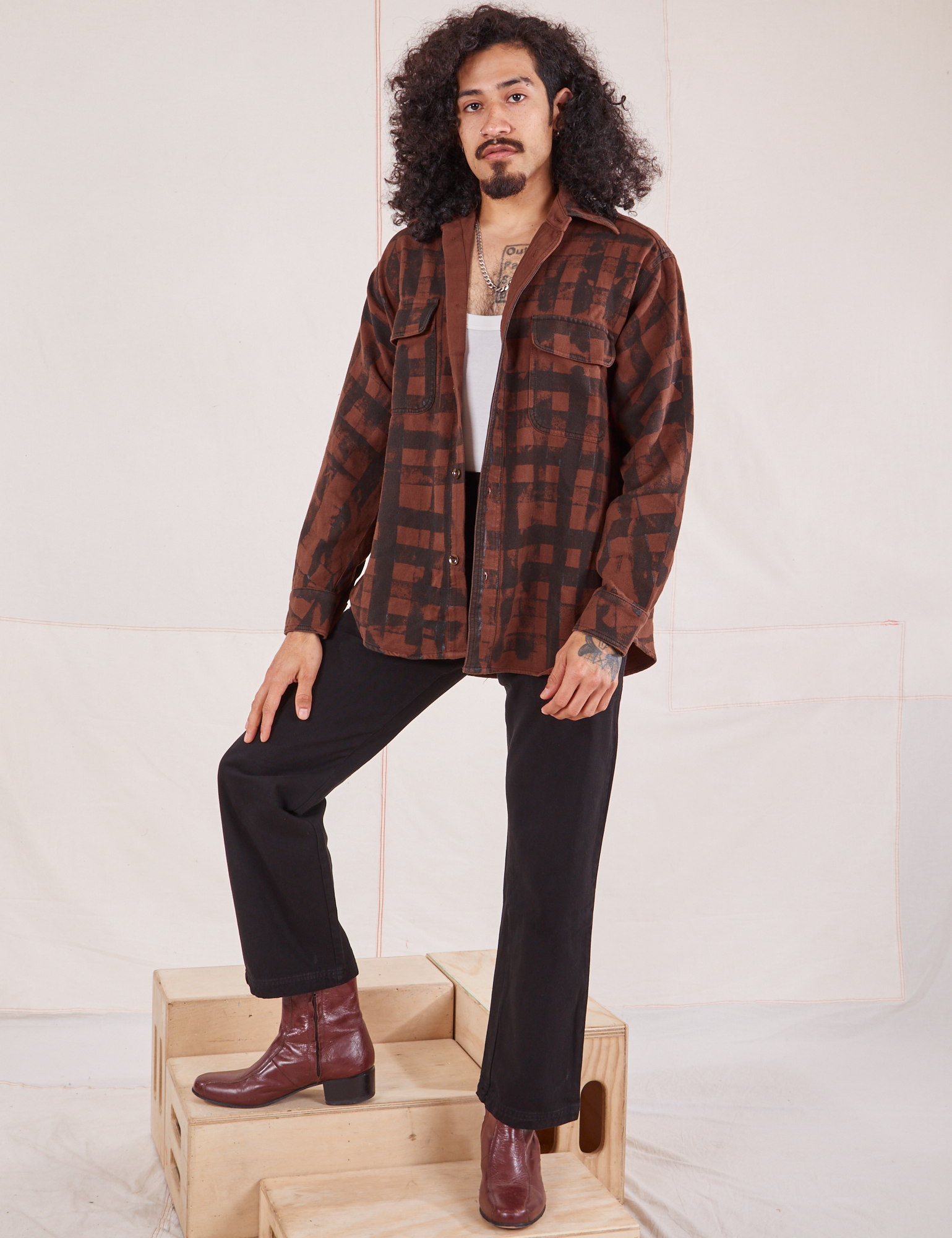 Jesse is wearing Plaid Flannel Overshirt in Fudgesicle Brown and black Work Pants