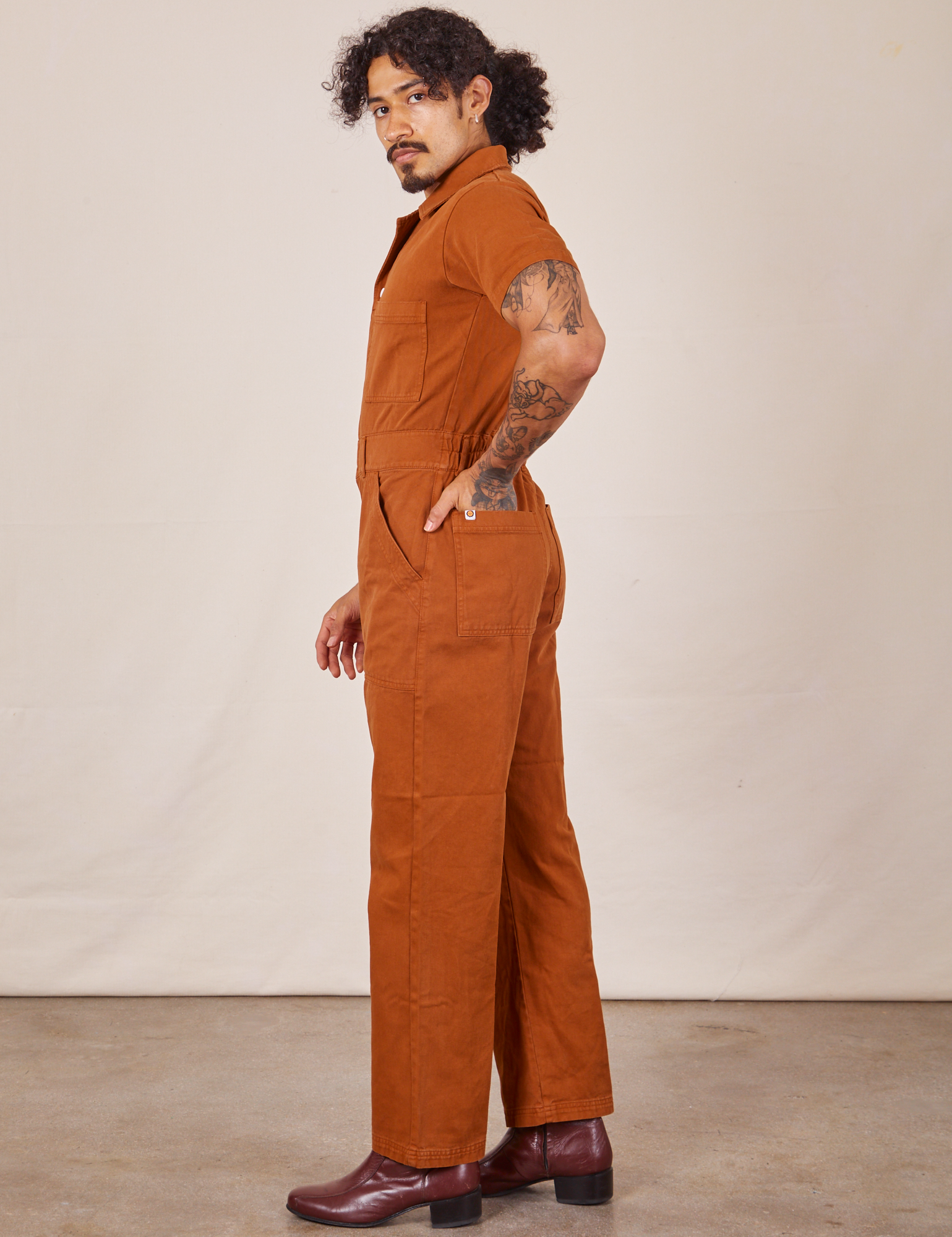 Side view of Short Sleeve Jumpsuit in Burnt Terracotta worn by Jesse