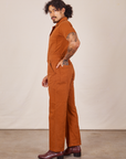Side view of Short Sleeve Jumpsuit in Burnt Terracotta worn by Jesse