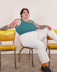 Sam is sitting on a yellow chair wearing Tank Top in Marine Blue and vintage tee off-white Western Pants