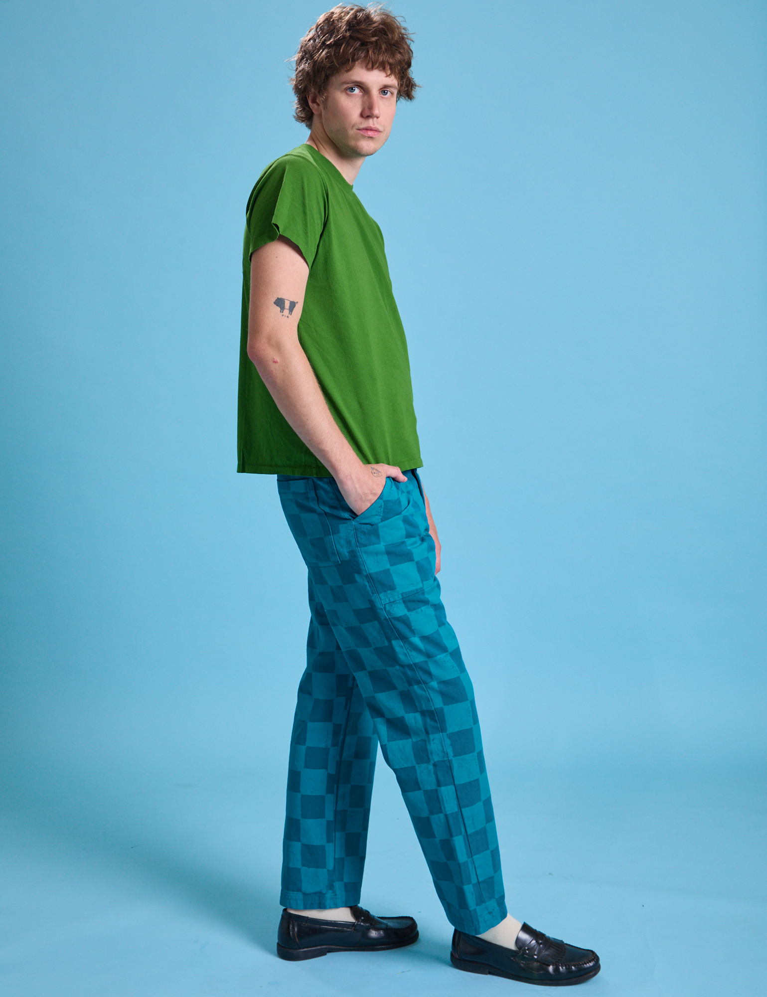 Side view of Checkerboard Work Pants in Blues and lawn green Organic Vintage Tee on Quinn