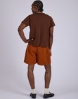 Back view of Pleated Trouser Shorts in Burnt Terracotta and fudgesicle brown Organic Vintage Tee