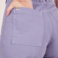 Back pocket close up of Western Pants in Faded Grape. Alex has her hand in the pocket.