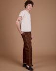 Side view of Carpenter Jeans in Fudgesicle Brown and Organic Vintage Tee in Vintage Tee Off-White on Quinn