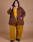 Sam is wearing Ripstop Field Coat in Fudgesicle Brown paired with spicy mustard in Drop Pocket Cargo Pants