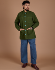 Jesse is wearing a buttoned up Ripstop Field Coat in Evergreen paired with french blue Drop Pocket Cargo Pants