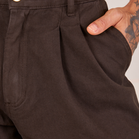 Front close up of Heavyweight Trousers in Espresso Brown. Jesse has their hand in the pocket.