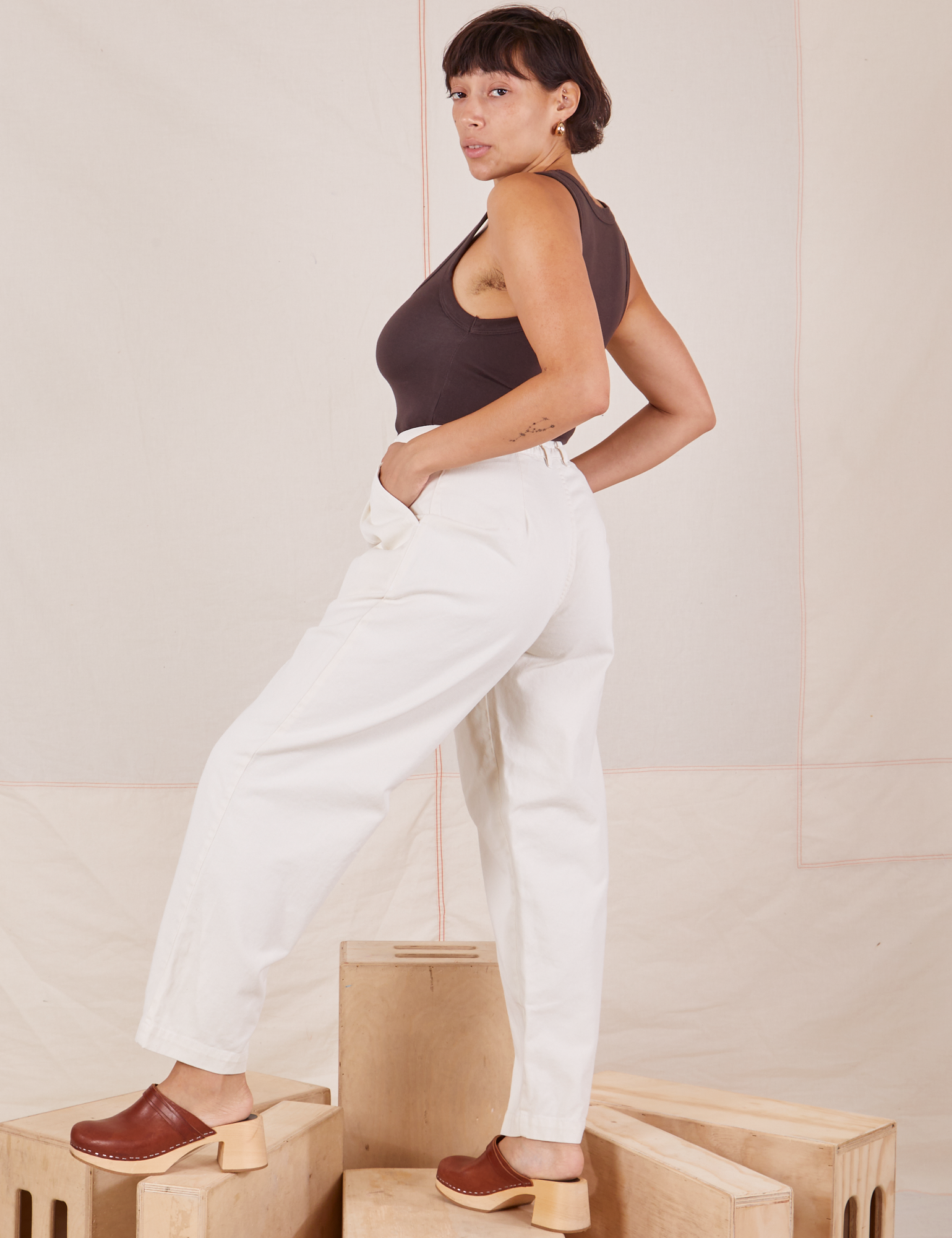 Side view of Heavyweight Trousers in Vintage Tee Off-White and espresso brown Cropped Tank Top worn by Tiara.