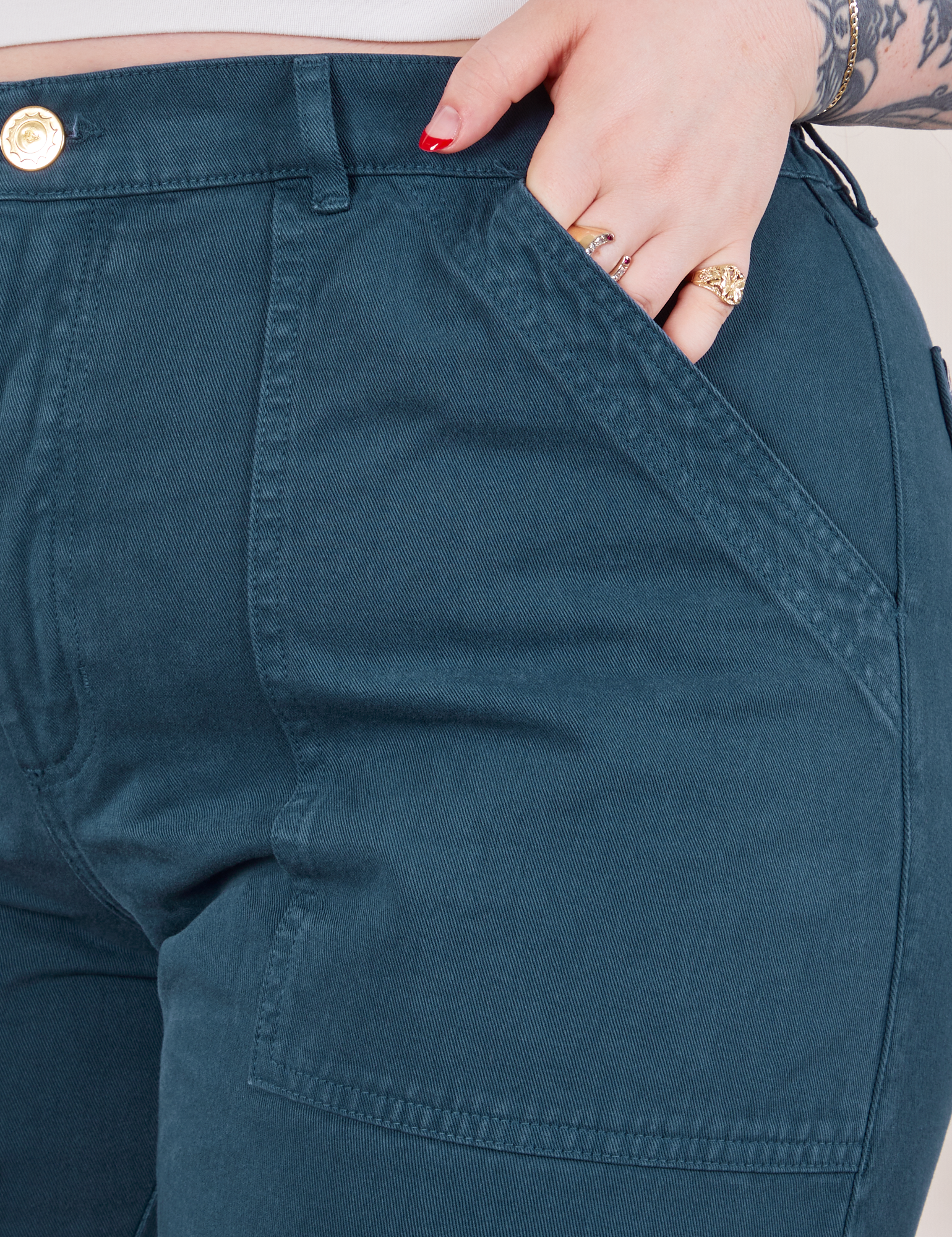 Work Pants in Lagoon front pocket close up. Sydney has her hand in the pocket.