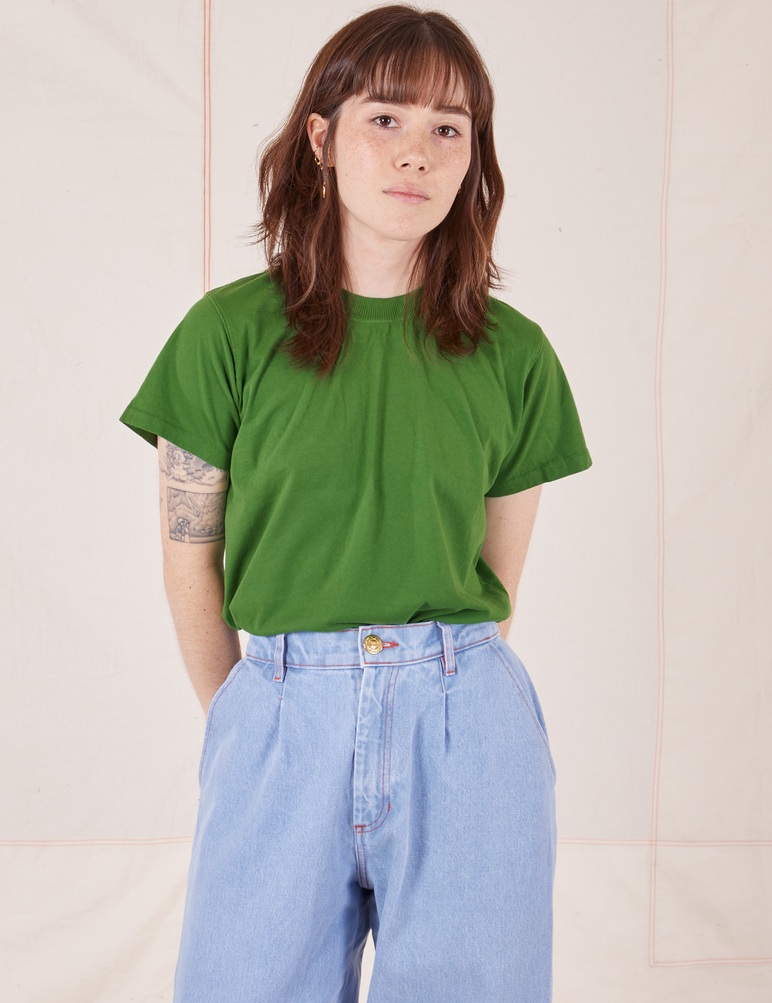 Hana is wearing Organic Vintage Tee in Lawn Green tucked into light wash Trouser Jeans