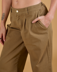 Close up of Alex's hand in the front pocket of Baggy Mid-Rise Trousers in Desert Brown