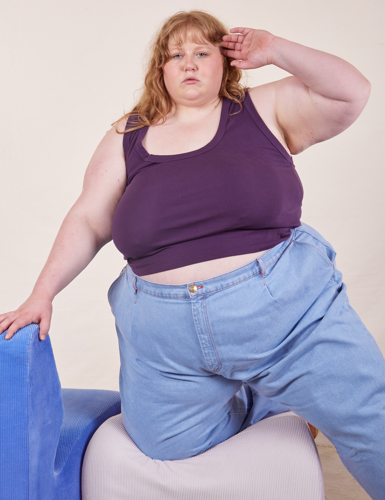 Catie is wearing Cropped Tank Top in Nebula Purple and light wash Denim Trousers