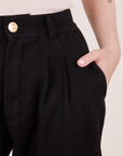 Front close up of Organic Trousers in Basic Black. Hana has her hand in the pocket.