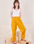 Hana is 5'3" and wearing XXS Petite Organic Trousers in Mustard Yellow paired with Cropped Cami in vintage tee off-white