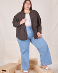Marielena is wearing Oversize Overshirt in Espresso Brown, vintage off-white Cropped Tank Top and light wash Sailor Jeans