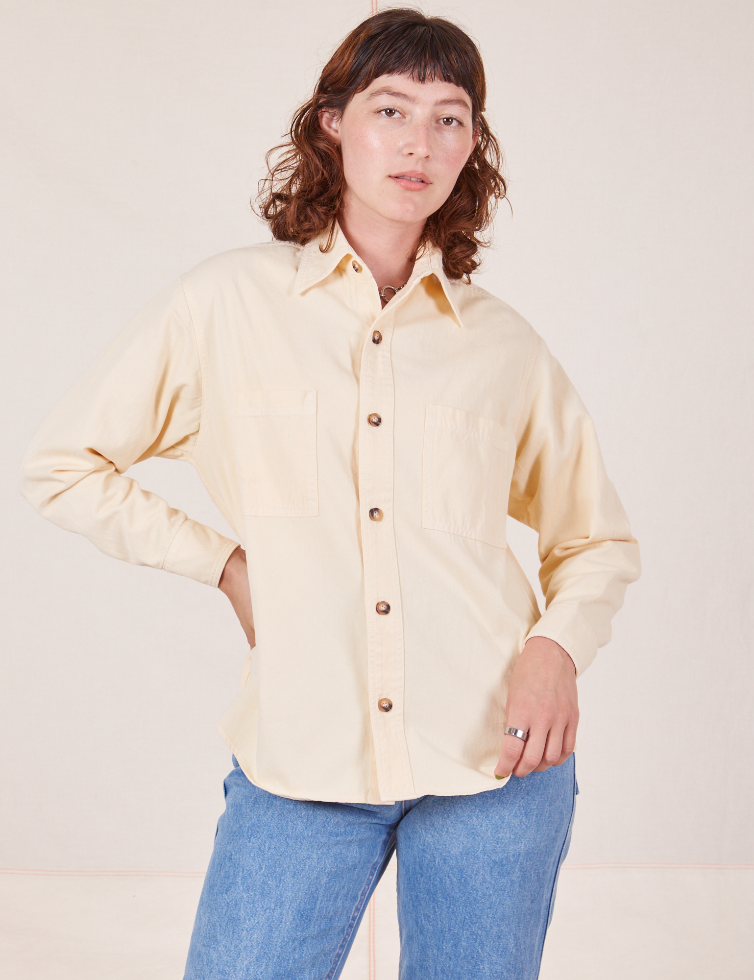 Alex is wearing a buttoned up Oversize Overshirt in Vintage Tee Off-White 