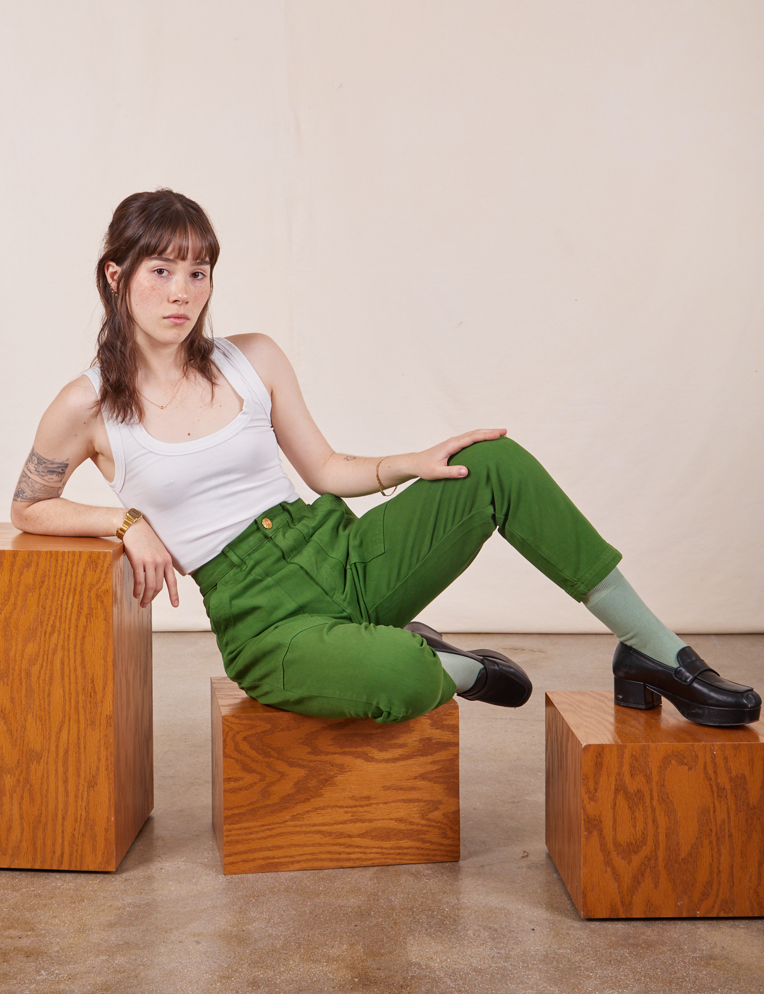 Hana is wearing Petite Pencil Pants in Lawn Green and Cropped Tank Top in vintage tee off-white