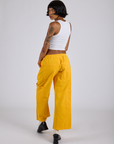 Angled back view of Drop Pocket Cargo Pants in Sunshine Yellow on Kira