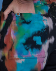Close up of Alex's hand in the back pocket of Work Pants in Rainbow Magic Waters