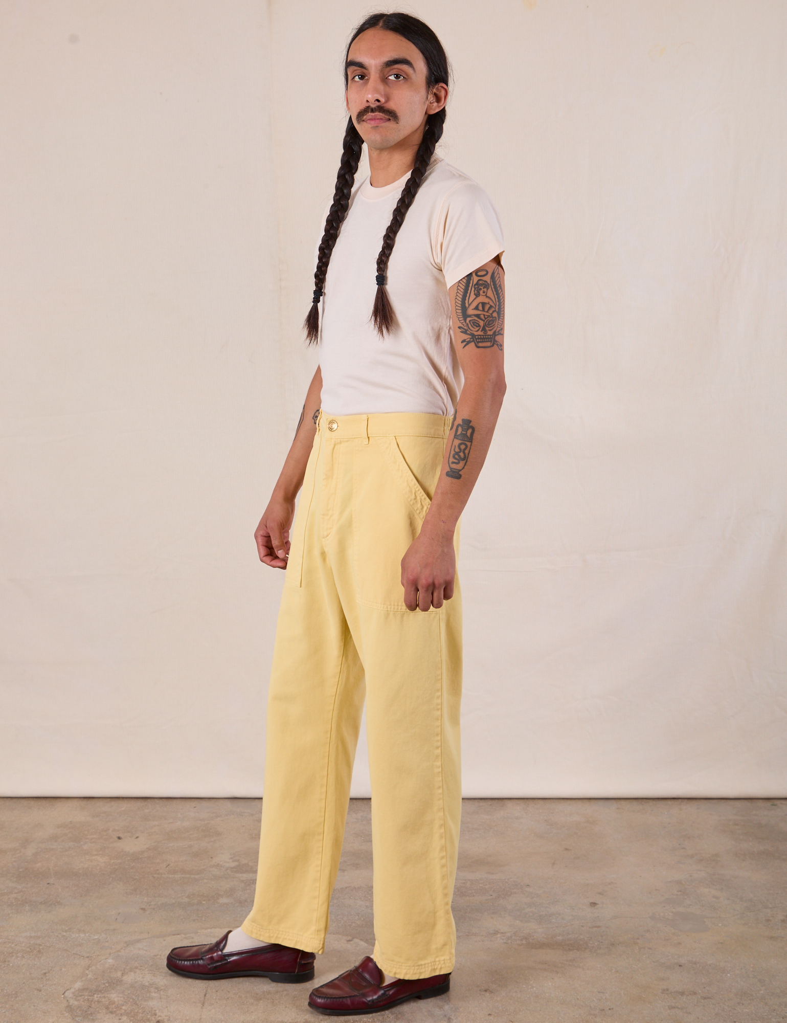 Side view of Work Pants in Butter Yellow and Organic Vintage Tee in Vintage Tee Off-White on Anthony