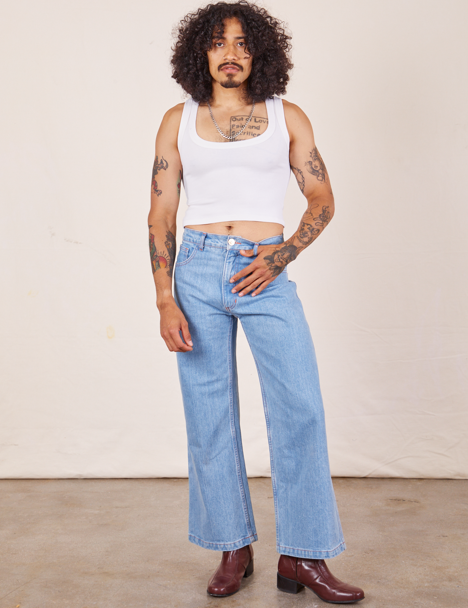 Jesse is wearing Cropped Tank Top in Vintage Tee Off-White paired with light wash Sailor Jeans