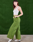 Side view of Overdyed Wide Leg Trousers in Gross Green and vintage off-white Cropped Tank Top on Alex
