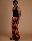Side view of Black Stripe Work Pants in Construction Orange and black tank top on Isaac