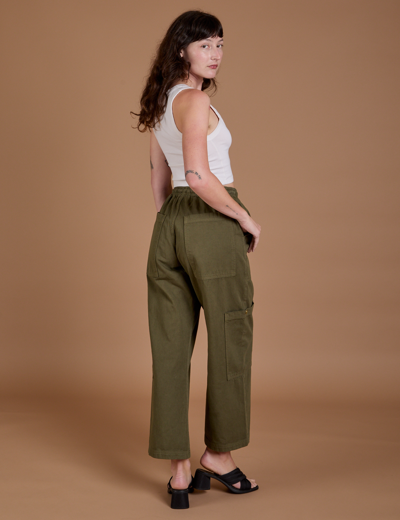 Angled back view of Drop Pocket Cargo Pants in Surplus Green on Alex