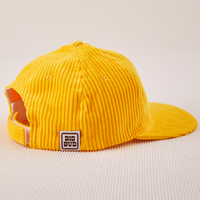 Side view of Dugout Corduroy Hat in Sunshine Yellow. Big Bud label sewn on edge of hat.