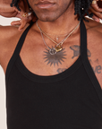 Front close up of Halter Top in Basic Black worn by Jerrod. They are holding onto the straps of the halter top.