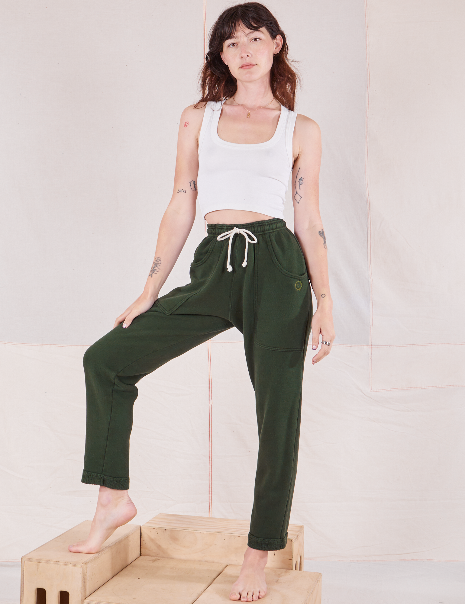 Alex is wearing Rolled Cuff Sweat Pants in Swamp Green and Cropped Tank in vintage tee off-white