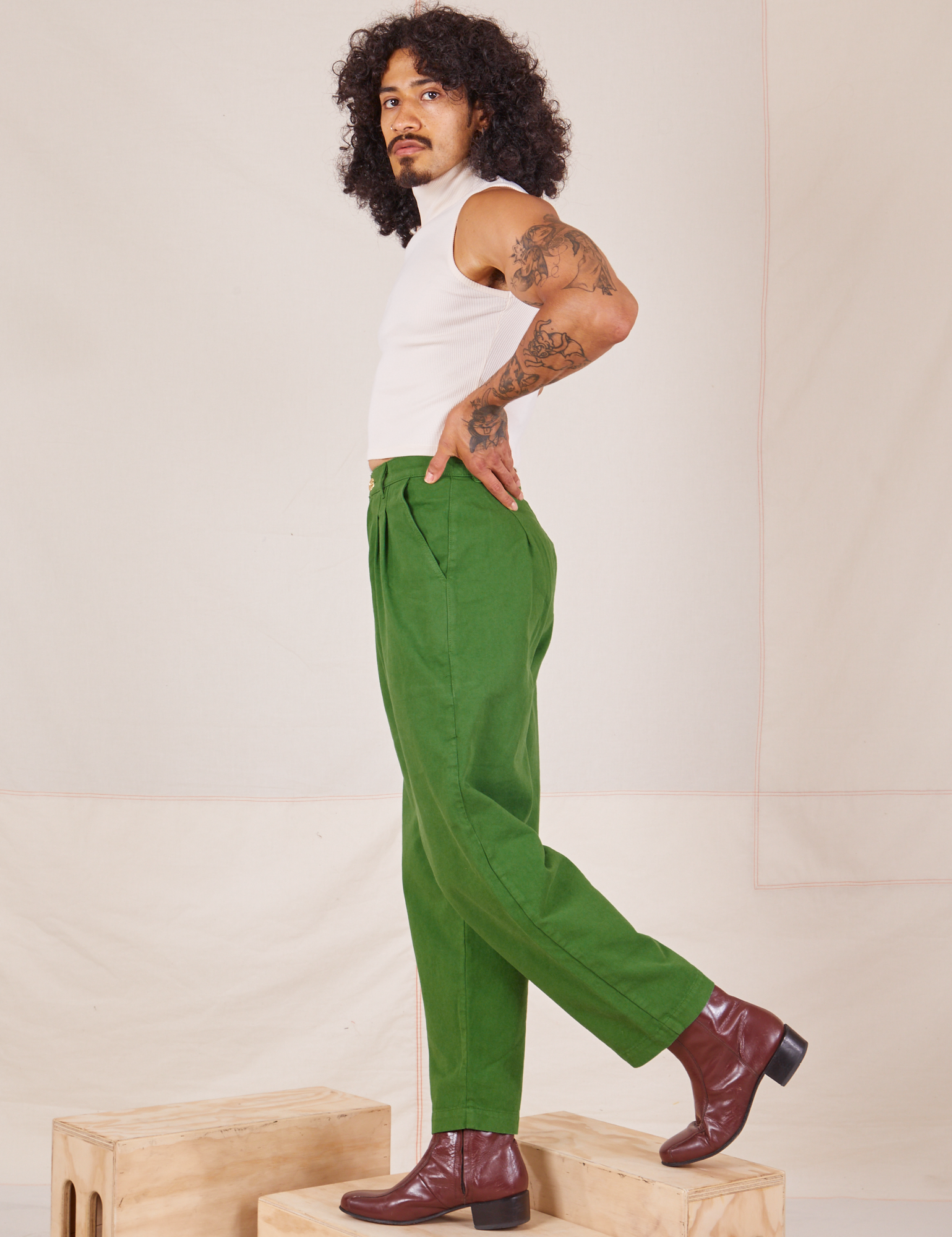 Side view of Heavyweight Trousers in Lawn Green and Sleeveless Turtleneck in vintage tee off-white worn by Jesse