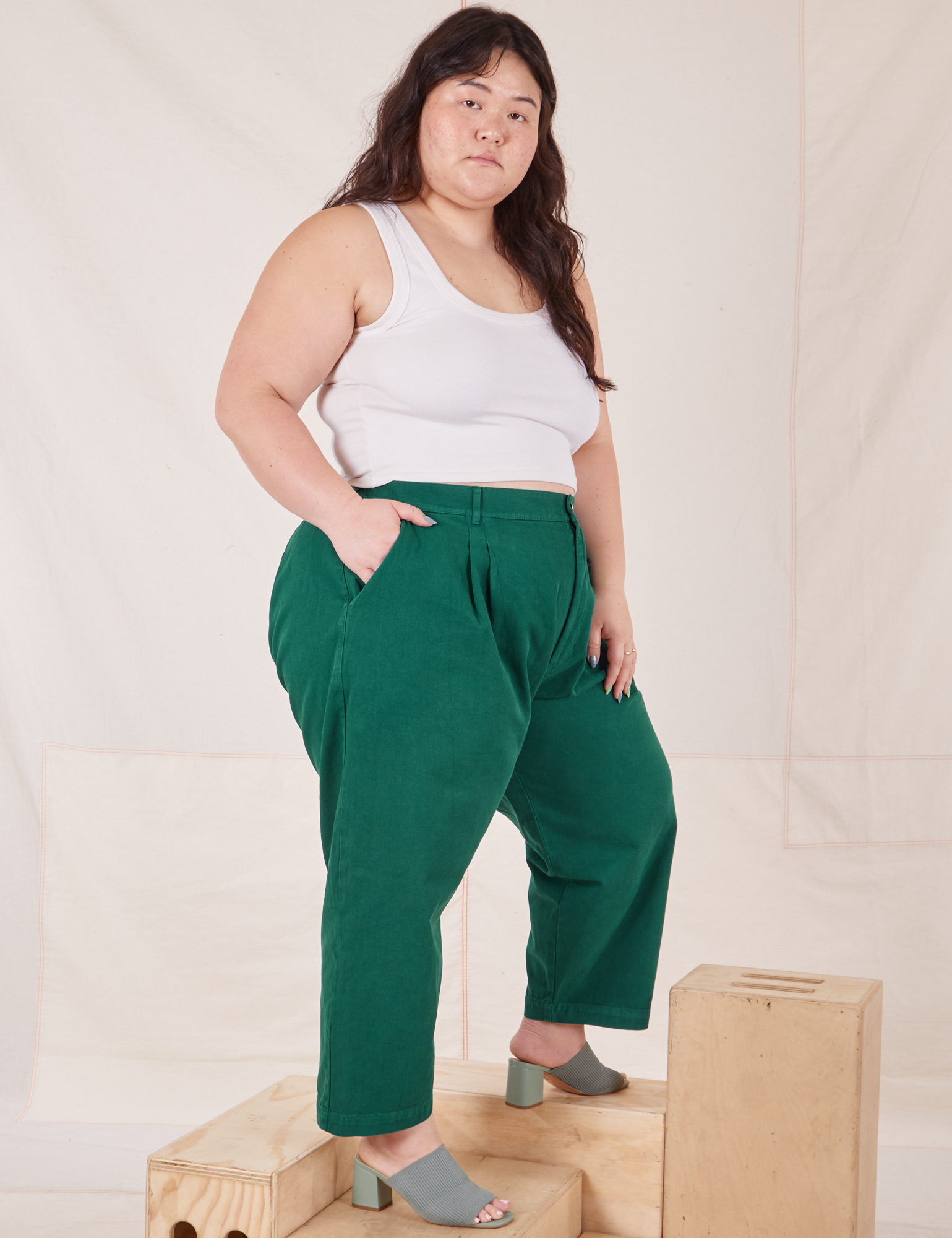 Angled view of Heavyweight Trousers in Hunter Green and Cropped Tank Top in vintage tee off-white worn by Ashley