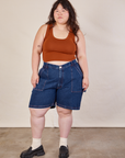 Ashley is 5'7" and wearing 1XL Carpenter Shorts in Dark Wash paired with burnt terracotta Cropped Tank