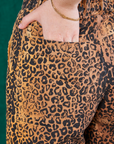 Leopard Work Pants back pocket close up. Hana has her hand in the pocket.