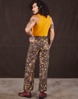 Back view of Marble Splatter Work Pants in Espresso Brown and mustard yellow Tank Top on Jesse