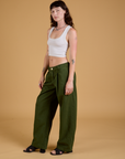 Angled front view of Baggy Mid-Rise Trousers in Evergreen and vintage tee white Cropped Tank on Alex