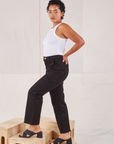 Side view of Organic Work Pants in Basic Black and Racerback Tank in vintage tee off-white on Mika