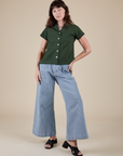 Alex is wearing Pantry Button-Up in Swamp Green and light wash Indigo Wide Leg Trousers