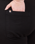 Petite Pencil Pants in Basic Black back pocket close up. Ashley has her hand in the pocket.