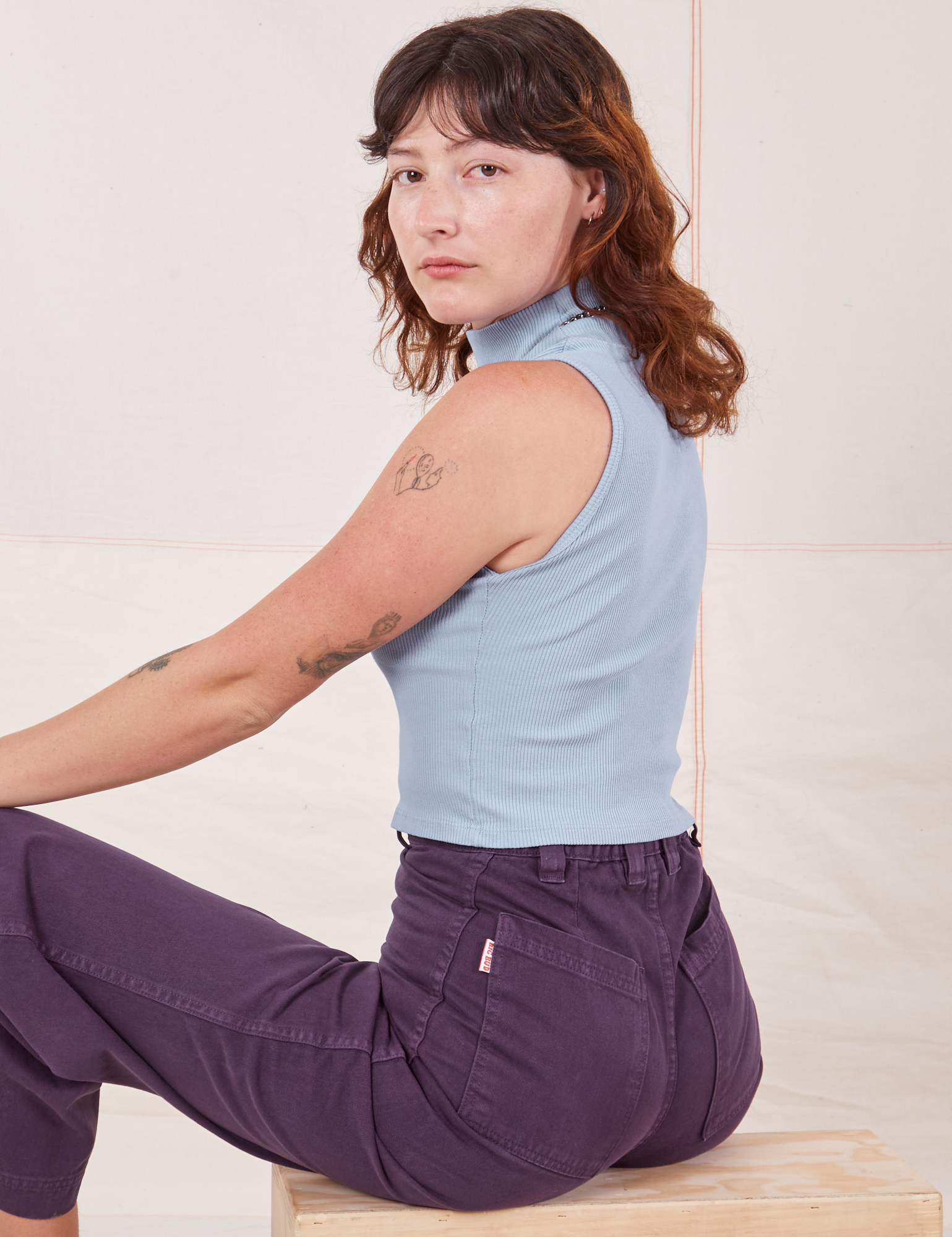 Angled back view of Sleeveless Essential Turtleneck in Periwinkle and nebula purple Bell Bottoms on Alex