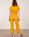 Back view of Short Sleeve Jumpsuit in Mustard Yellow worn by Alex