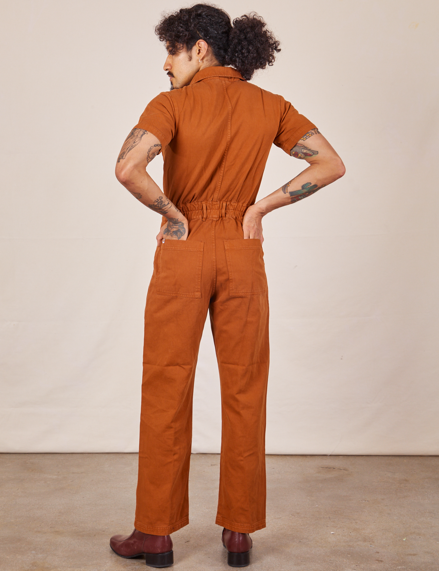 Back view of Short Sleeve Jumpsuit in Burnt Terracotta worn by Jesse