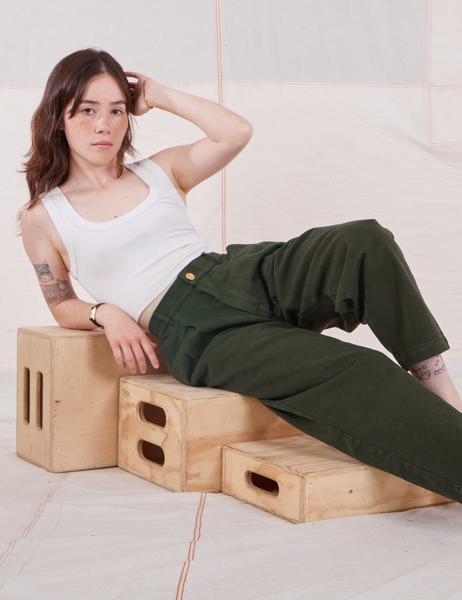 Hana is wearing Heavyweight Trousers in Swamp Green and Cropped Tank Top in vintage tee off-white