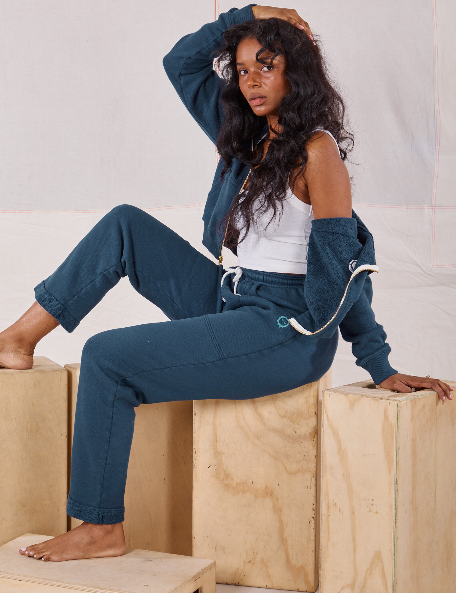 Kandia is wearing Cropped Zip Hoodie in Lagoon, vintage off-white Cropped Tank and matching Rolled Cuff Sweat Pants