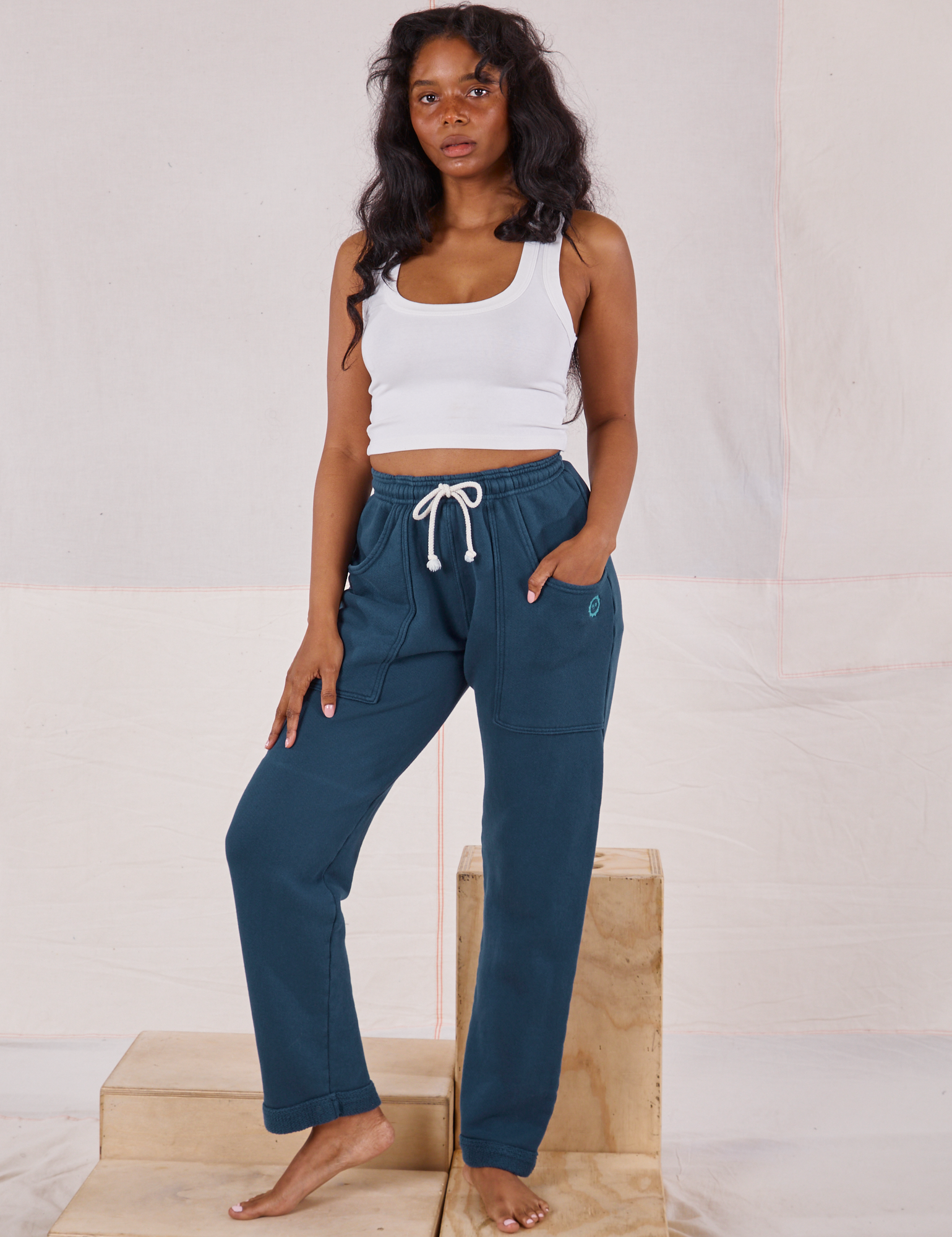 Kandia is 5&#39;3&quot; and wearing P Rolled Cuff Sweat Pants in Lagoon and vintage off-white Cropped Tank Top