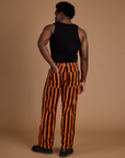 Back view of Black Stripe Work Pants in Construction Orange and black tank top on Isaac