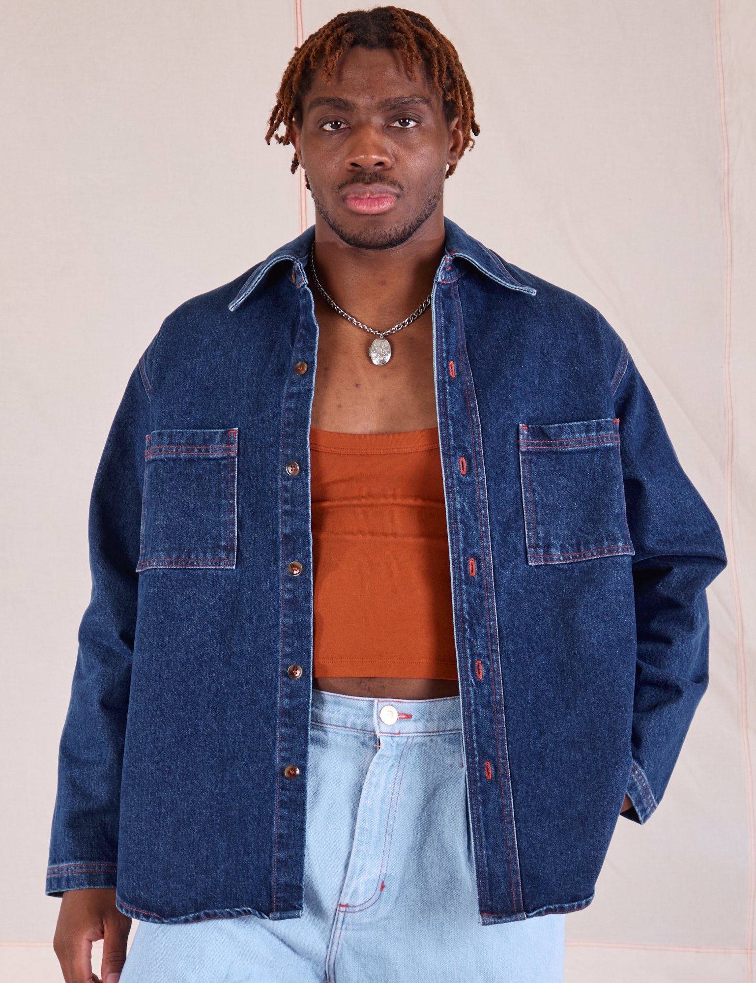Issac is 5'10" and wearing S Denim Overshirt in Dark Wash worn with a burnt terracotta Cropped Tank underneath